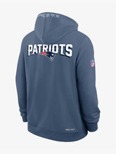 Storm blue Patriots hoodie with large PATRIOTS wordmark and logo across the shoulders and script detail on the hood