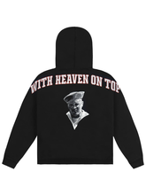 Black fleece hoodie with arched white and red With Heaven On Top lettering and a black-and-white sailor portrait on the back
