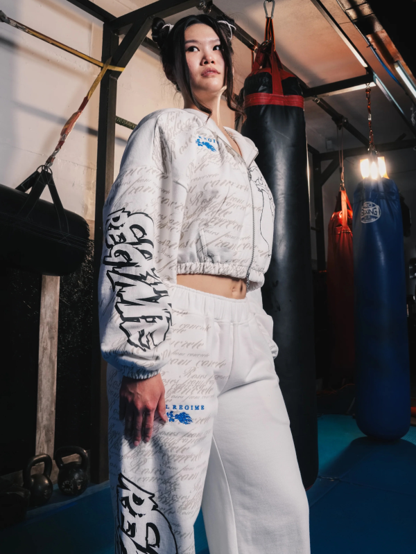 Woman wearing white Civil Regime Street Fighter cropped hoodie and sweatpants