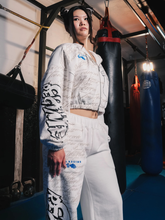 Woman wearing white Civil Regime Street Fighter cropped hoodie and sweatpants