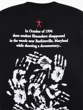 Close-up of Blair Witch tee back print showing found-footage story text and overlapping white handprints
