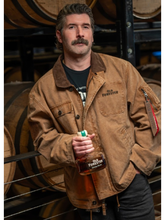 Man wearing Old Forester Alpha Industries bourbon brown jacket holding whiskey bottle