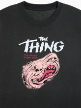 Close-up of black t-shirt back print showing monstrous creature illustration in blue and white for The Thing